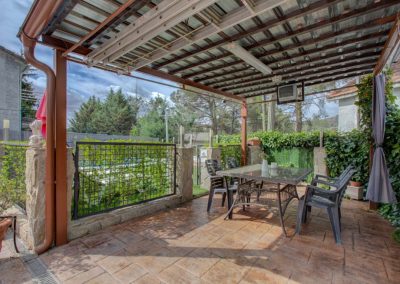 Terraza exterior con mesa y cenador en Casa Rural Higueras Madrid